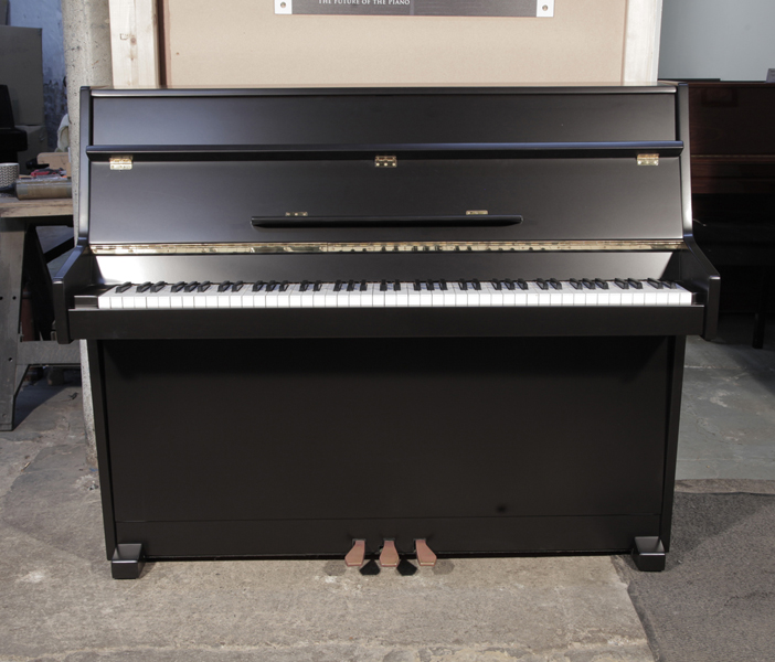 Pre-owned, 1988, Young Chang U-109 upright piano with a black, satin case and brass fittings. Piano has an eighty-eight note keyboard and two pedals. .